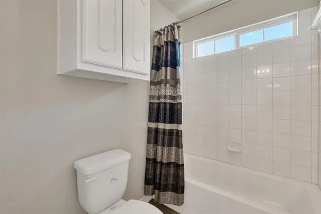 a bathroom with a toilet and a shower