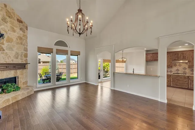 a view of an empty room with wooden floor and a fireplace