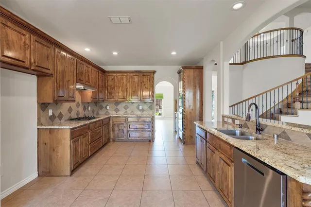 a kitchen with stainless steel appliances granite countertop a sink counter space cabinets and a large window