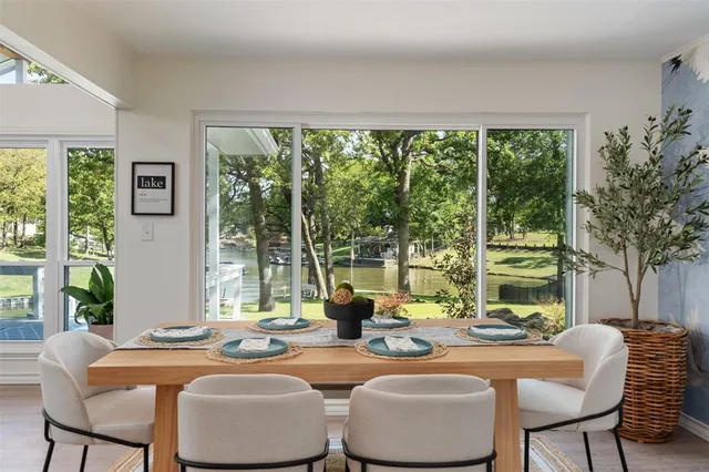 a dining room with furniture large windows and wooden floor