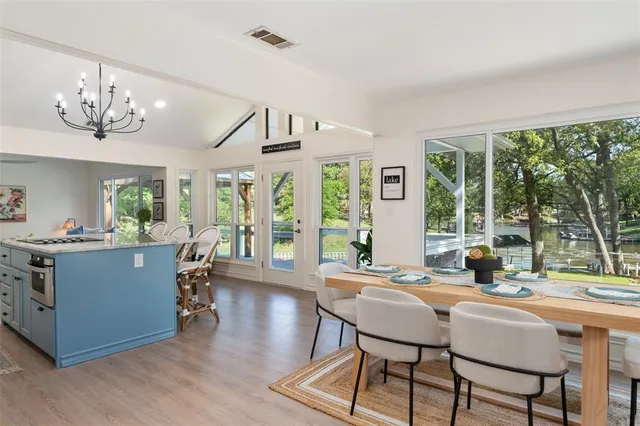 a dining room with wooden floor and large windows