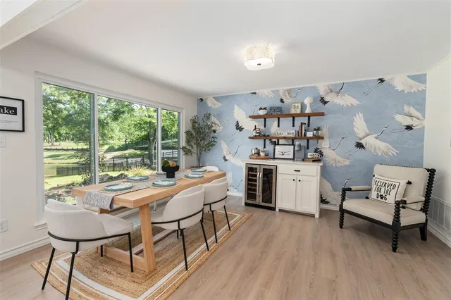 a room with a table chairs and a large window