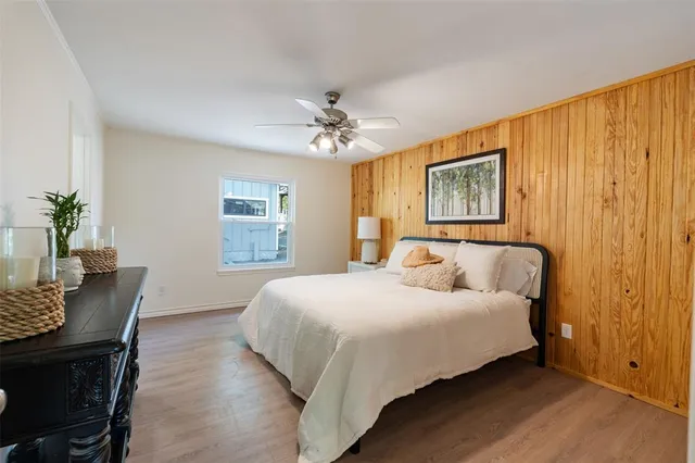 a bedroom with a bed chandelier and a window