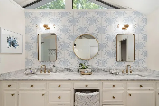 a bathroom with a granite countertop double vanity sink and a mirror