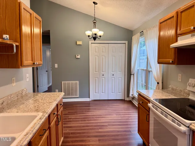 a bathroom with a granite countertop sink toilet and mirror