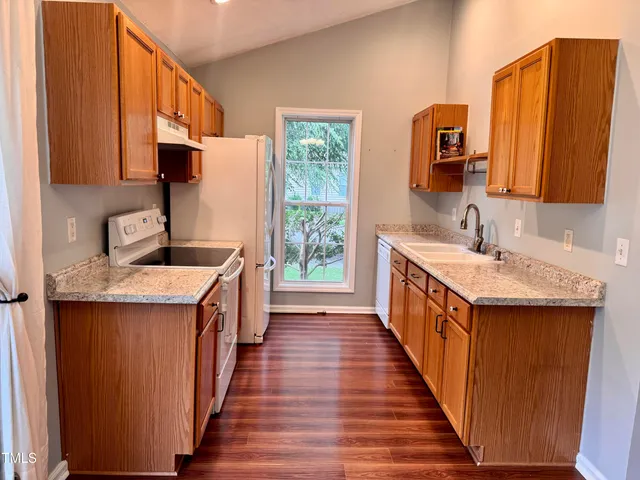 a bathroom with a granite countertop sink toilet and mirror