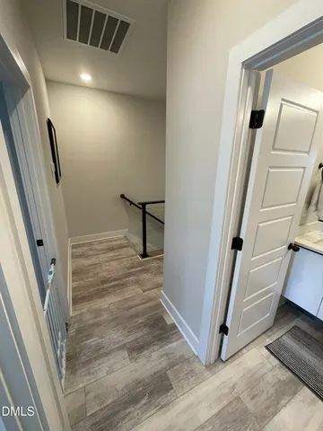 a living room with couches chairs and kitchen view with wooden floor