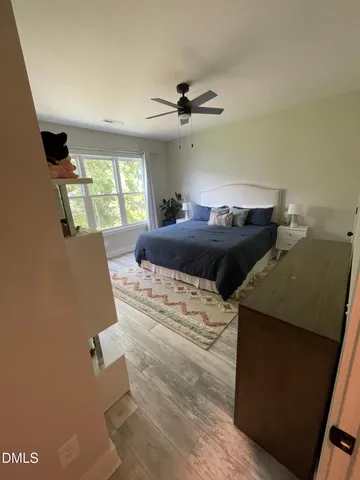 a bedroom with a bed and a lamp on the dresser