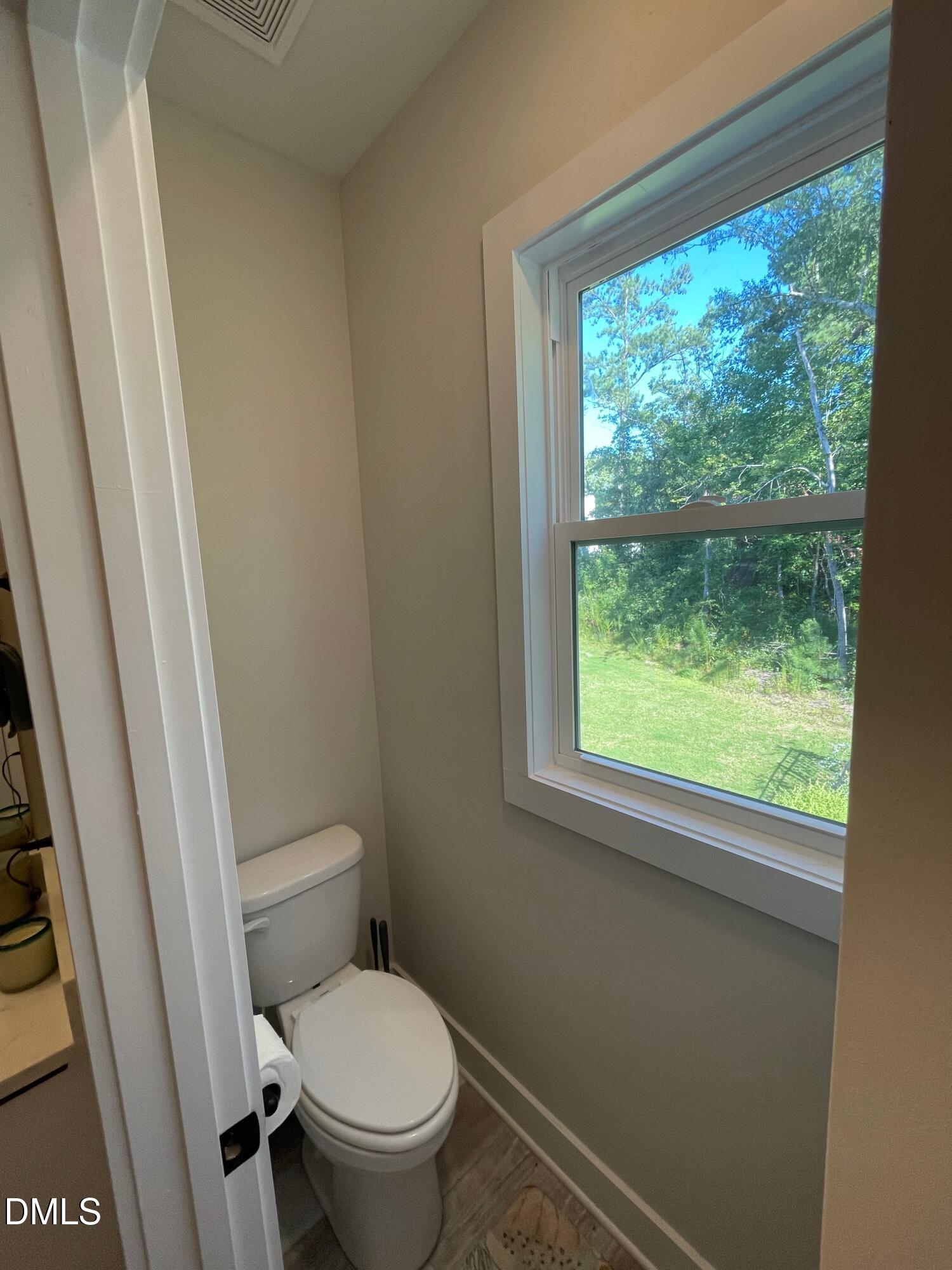 4108 Convergence Street Durham, NC 27704 - Photo 24 of 31 a white toilet sitting in a bathroom next to a window