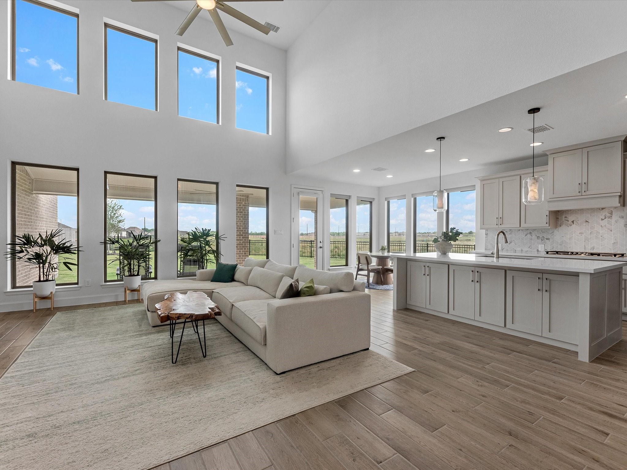 18714 Pistachio Way Manvel, TX 77578 - Photo 1 of 48 Dramatic two-story ceilings, walls of windows, and an open-concept design create a bright, inviting living space that seamlessly connects the family room, kitchen, and breakfast area.