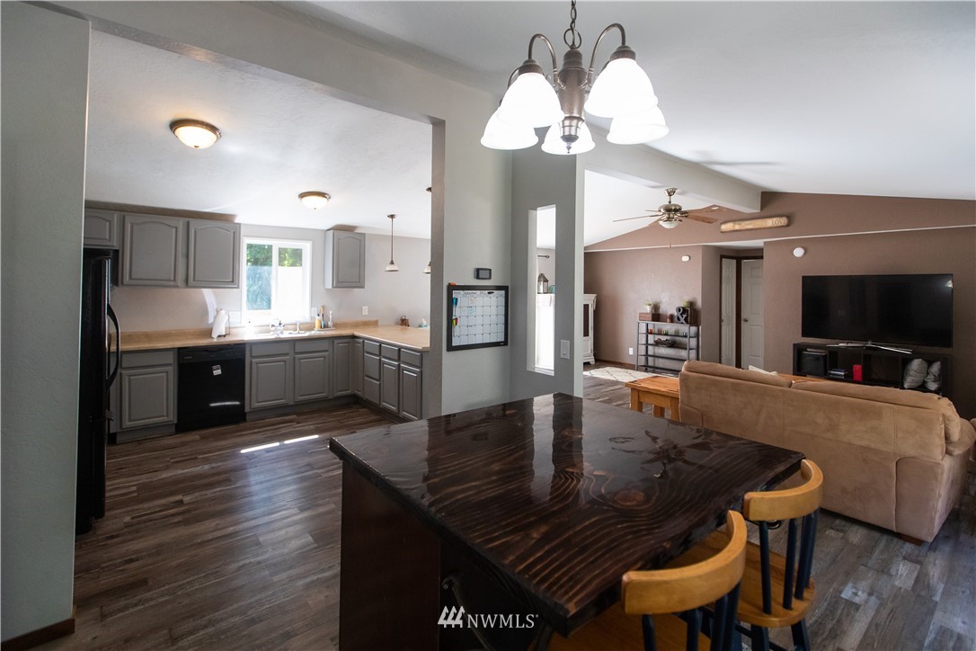 282 Woodard Road, Unit 79 Napavine, WA 98532 - Photo 22 of 29 a large kitchen with granite countertop a stove a sink a dining table and chairs