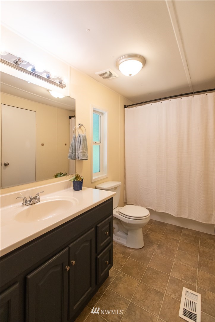 282 Woodard Road, Unit 79 Napavine, WA 98532 - Photo 25 of 29 a bathroom with a granite countertop sink a toilet and a mirror