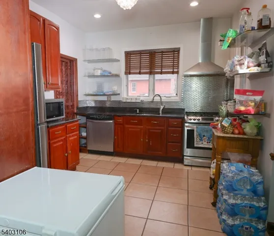 a kitchen with stainless steel appliances granite countertop a stove a sink and a refrigerator
