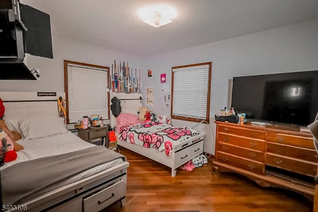 a bedroom with two beds and a flat screen tv