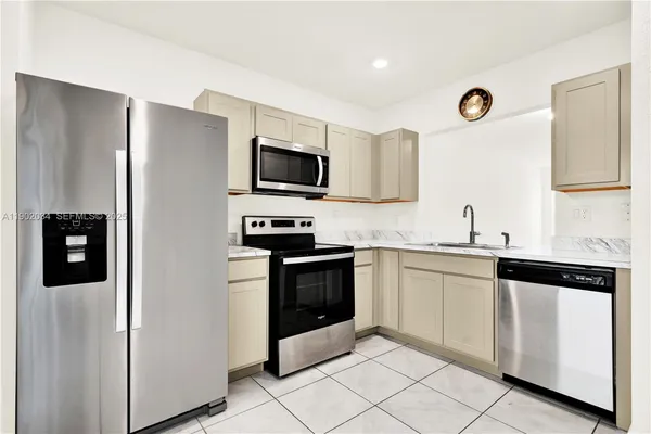 a kitchen with stainless steel appliances a refrigerator stove and microwave