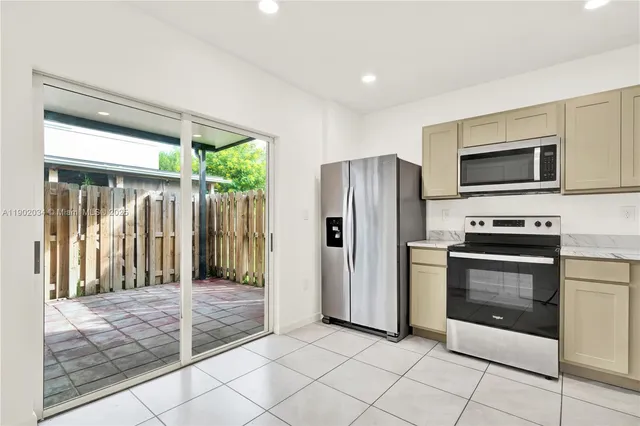 a kitchen with stainless steel appliances granite countertop a refrigerator and a stove top oven