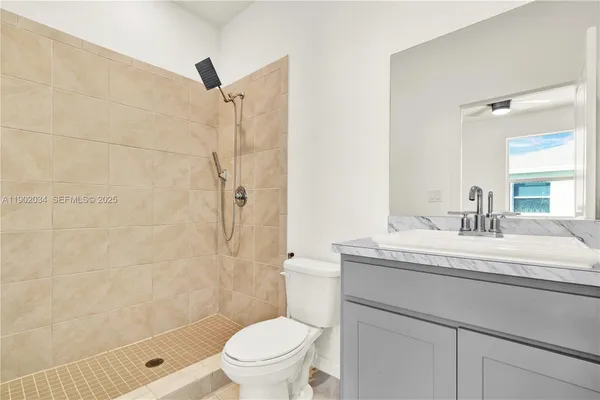 a bathroom with a granite countertop sink toilet and shower