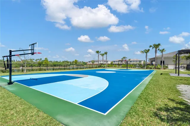 a front view of a house with a garden and palm trees