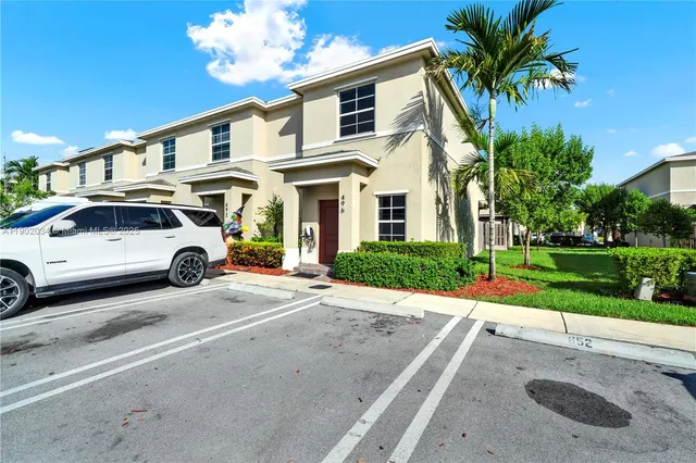 a front view of a house with a garden and parking