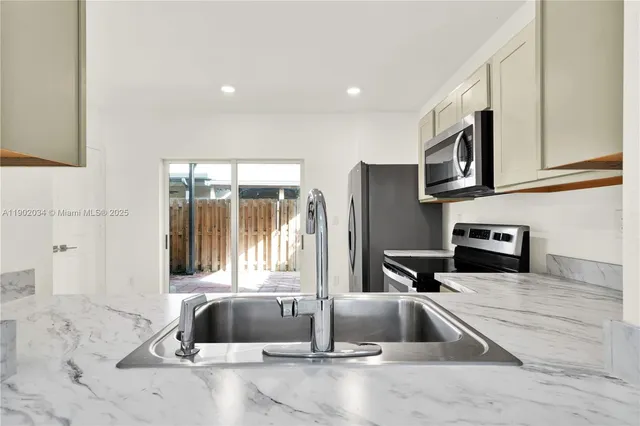 a kitchen with granite countertop a sink and a stove top oven