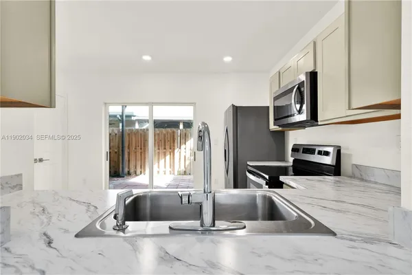 a kitchen with granite countertop a sink and a stove top oven