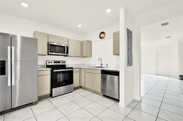 a kitchen with stainless steel appliances granite countertop a refrigerator and a stove top oven