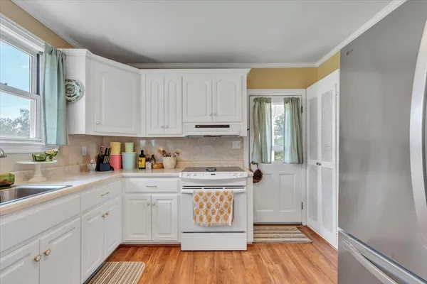 a kitchen with a sink window and cabinets