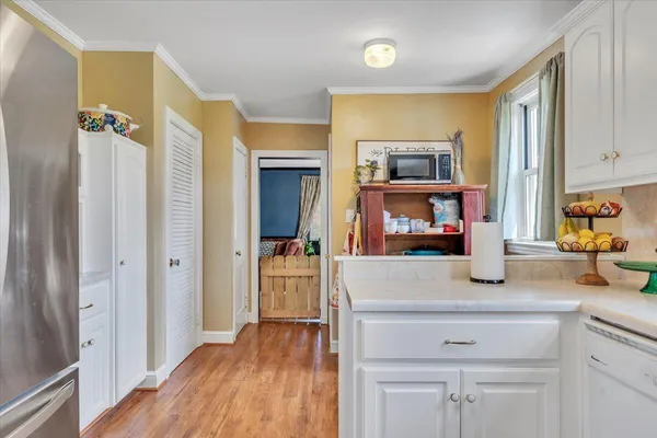 a kitchen with granite countertop white cabinets and stainless steel appliances