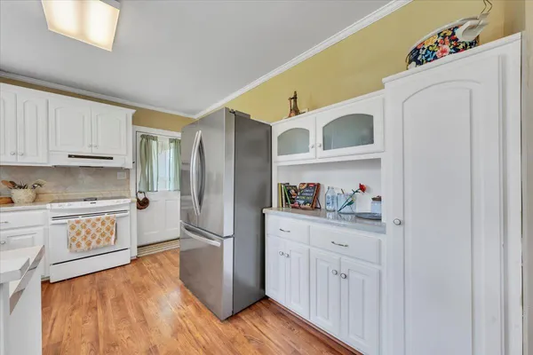 a living room with furniture and three windows