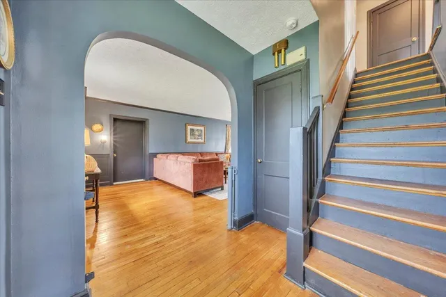 a view of a bedroom with wooden floor and staircase