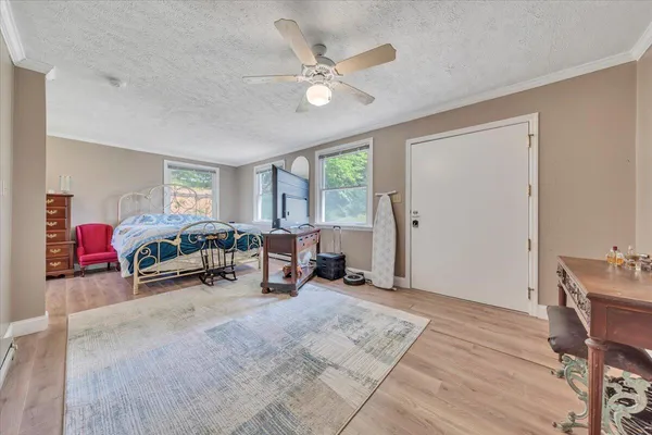a bedroom with a bed and large windows