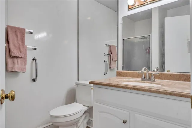 a bedroom with a bed and dresser with wooden floor