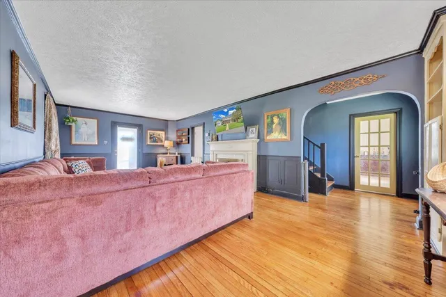 a living room with furniture a fireplace and a large window
