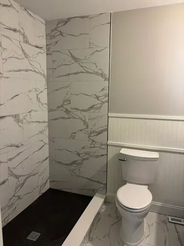 a bathroom with a toilet and a shower