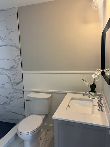 a bathroom with a sink a toilet and mirror