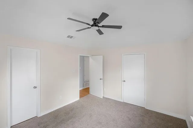 an empty room with closet and ceiling fan