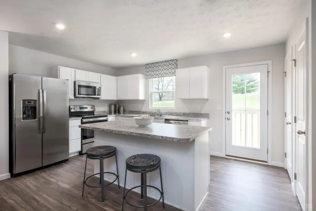 a kitchen with refrigerator cabinets and wooden floor
