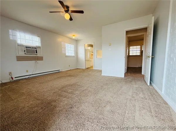an empty room with windows and fan