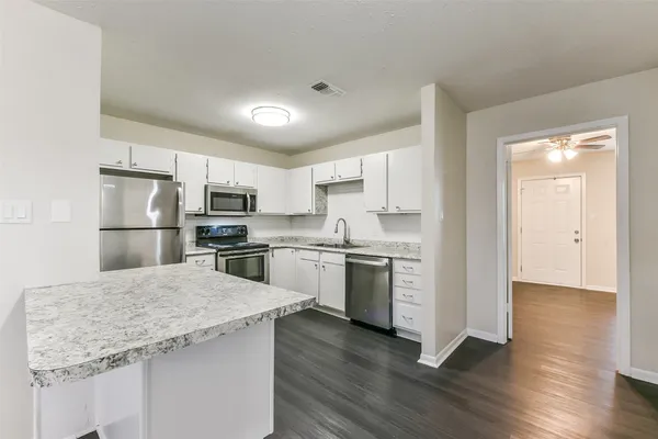 a kitchen with a refrigerator sink and cabinets