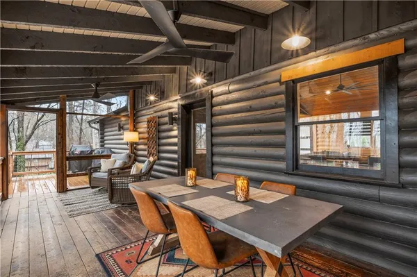 a view of a patio with table and chairs with wooden floor and fence