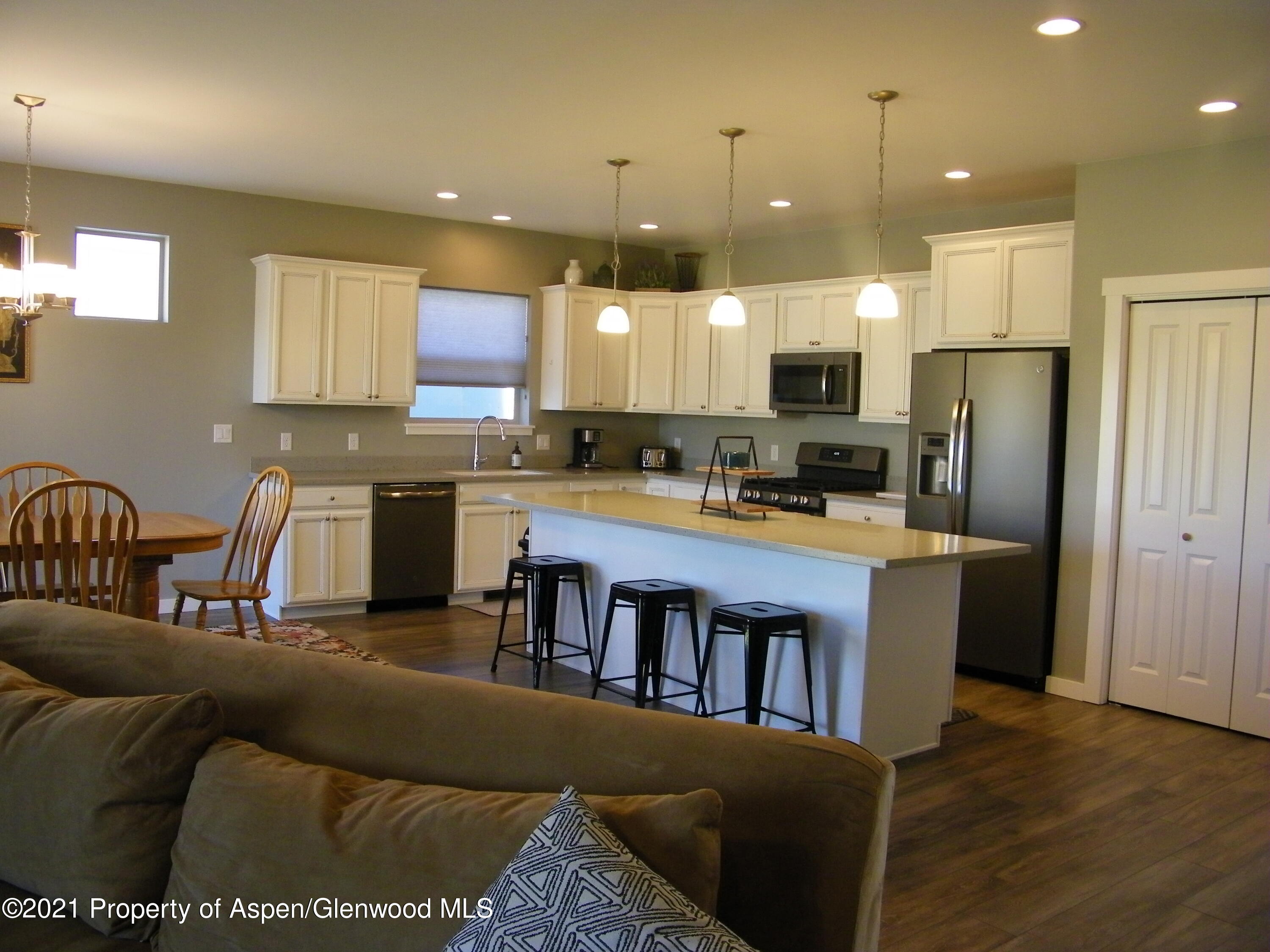 1717 Belgian Loop Silt, CO 81652 - Photo 4 of 16 a kitchen with stainless steel appliances granite countertop a refrigerator a stove top oven a sink dishwasher and white cabinets