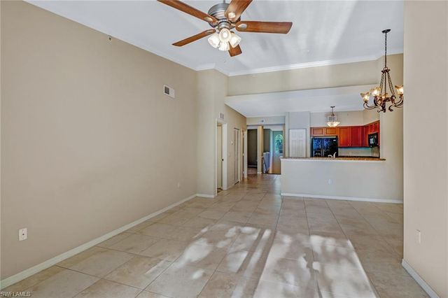 a view of a livingroom with a ceiling fan and kitchen view