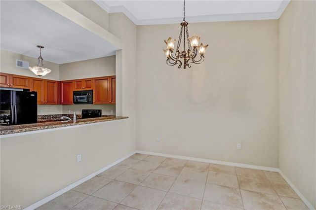 a view of kitchen with chandelier and refrigerator