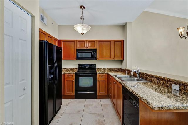 a kitchen with stainless steel appliances granite countertop a sink and a refrigerator