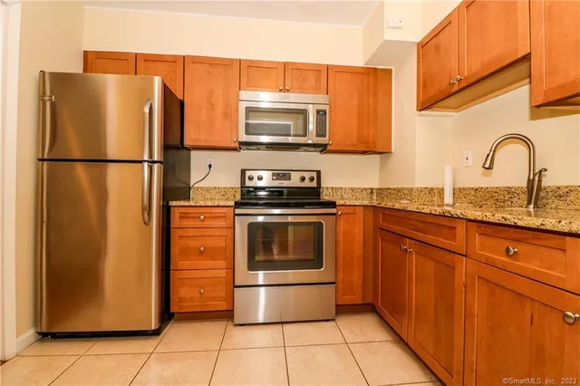 a kitchen with stainless steel appliances granite countertop a refrigerator and a sink