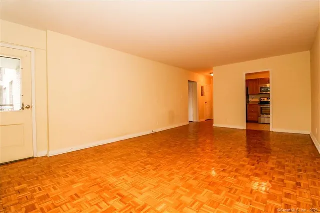 a view of empty room with wooden floor