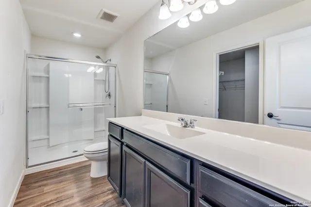 a bathroom with a sink a toilet and shower