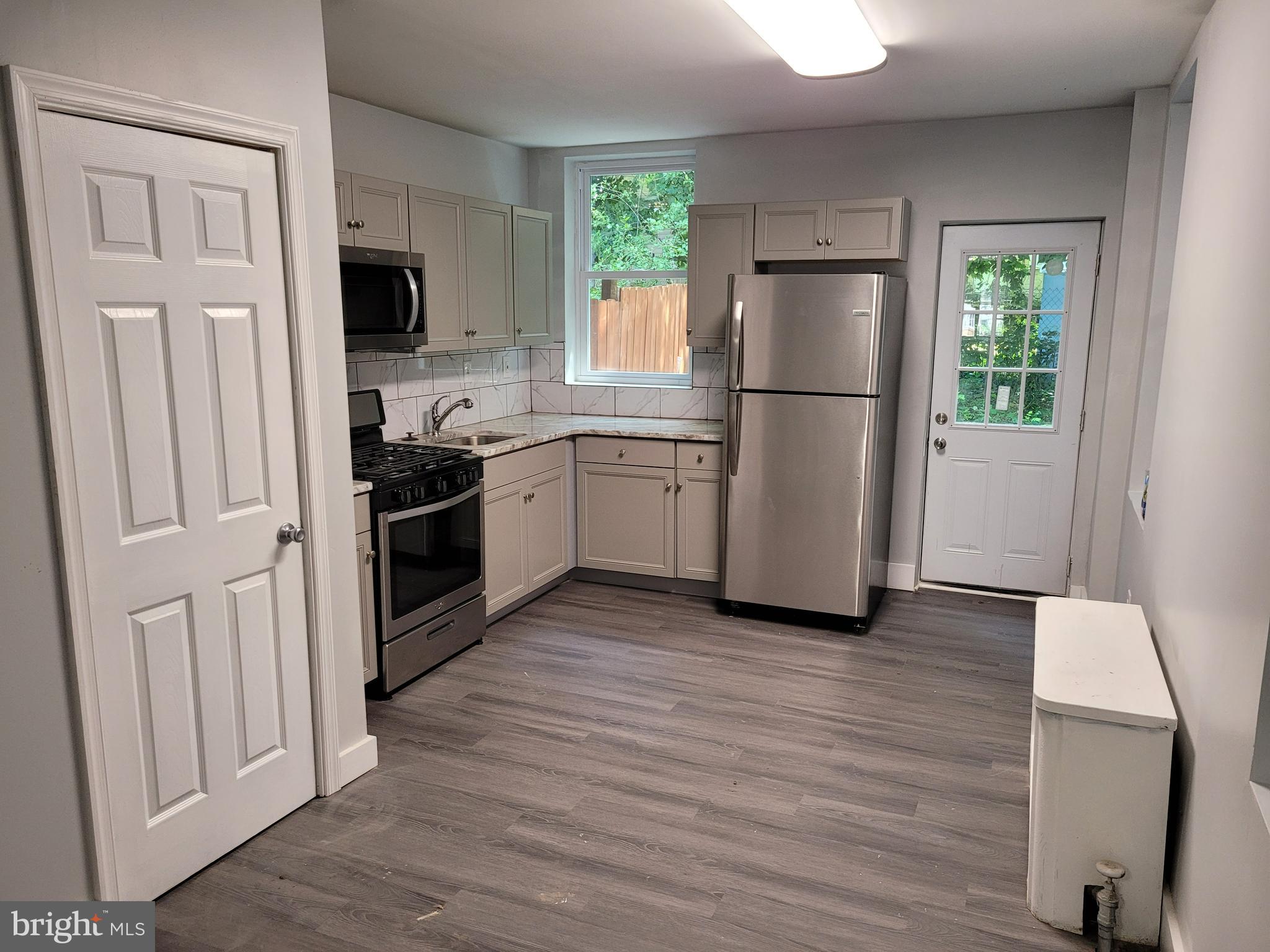 1422 Blavis Street Philadelphia, PA 19140 - Photo 3 of 20 a kitchen with a refrigerator sink and cabinets