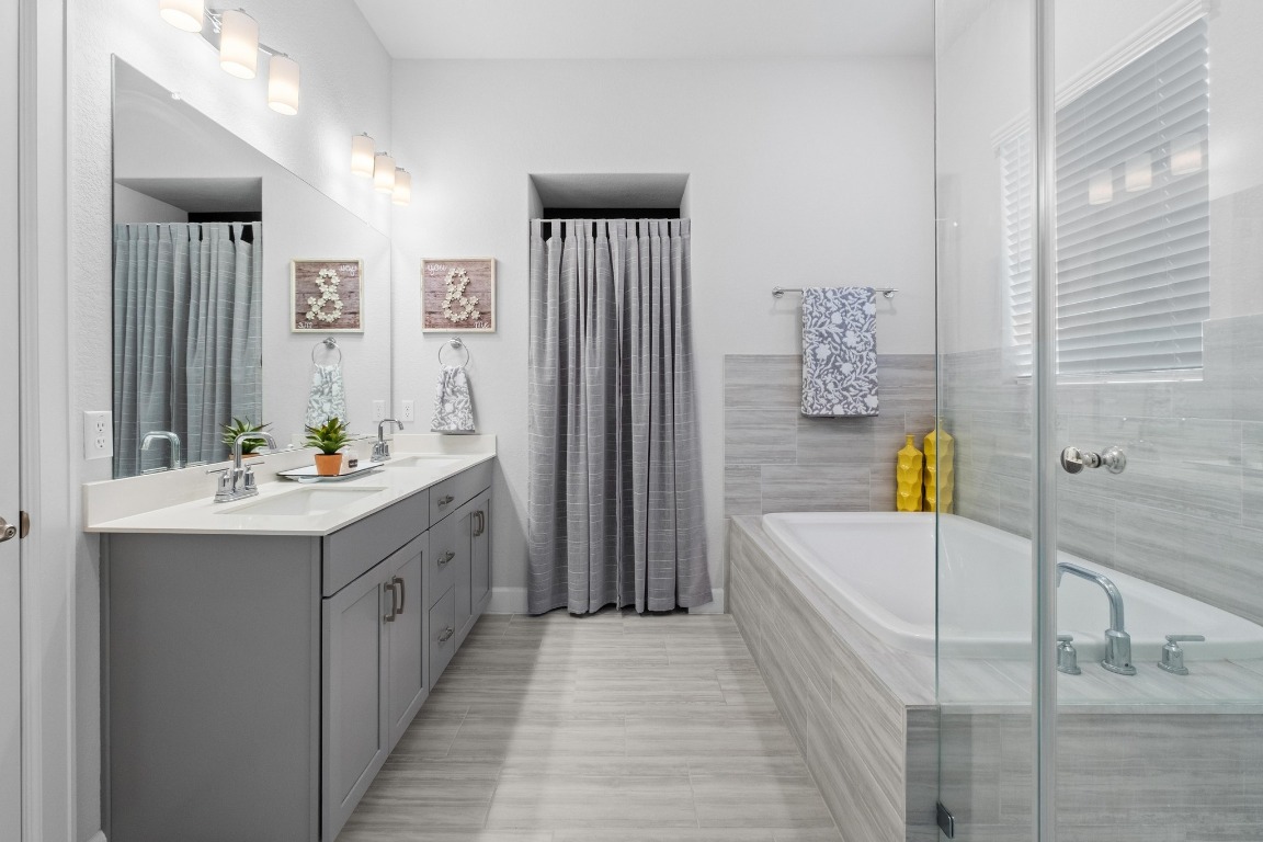 144 Monterey Oak Trail Georgetown, TX 78628 - Photo 12 of 28 a bathroom with a tub double vanity sink and mirror