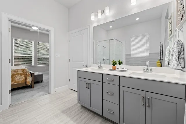 a bathroom with double vanity sink a window and a mirror